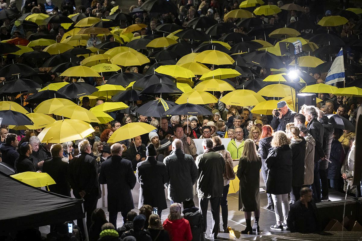 Menschen mit gelben und schwarzen Regenschirmen am 2. November in Zürich an einer genehmigten Kundgebung unter dem Motto #NeverAgainIsNow zum Gedenken an die Opfer des Hamas-Angriffs auf Zivilisten in Israel am 7. Oktober 2023. Foto: Keystone-SDA, Ennio Leanza.