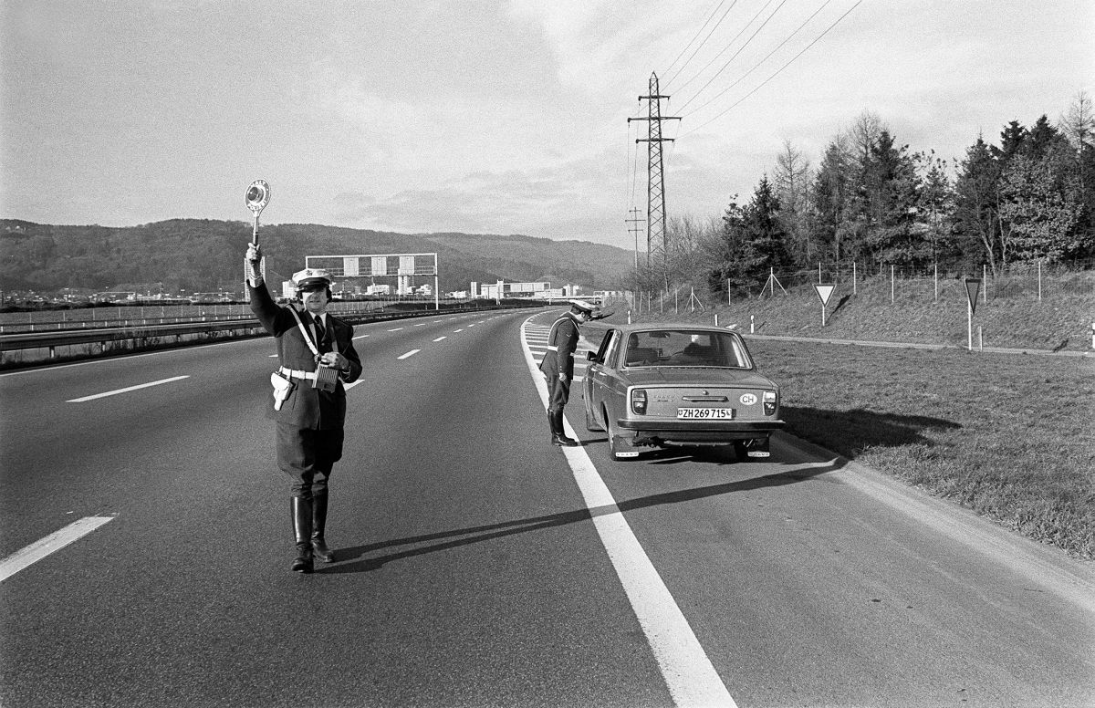 1605762 – Eine Polizeipatrouille kontrolliert ein Auto an einem der autofreien Sonntage im November / Dezember 1973 in der Schweiz. Foto: KEYSTONE 1605762 – Eine Polizeipatrouille kontrolliert ein Auto an einem der autofreien Sonntage im November / Dezember 1973 in der Schweiz. Foto: KEYSTONE