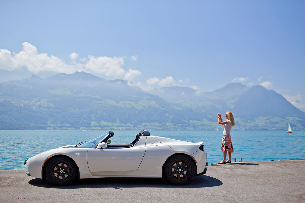 Eine Frau fotografiert am 19. Juli 2010 am Ufer des Vierwaldstättersees in Gersau. Sie ist mit einem «Tesla Roadster Sport» unterwegs. Elektroautos weisen über ihre gesamte Lebensdauer hinweg eine bessere Umweltbilanz auf als Fahrzeuge mit Verbrennungsmotor. Foto: Keystone-SDA/Gaëtan Bally Eine Frau fotografiert am 19. Juli 2010 am Ufer des Vierwaldstättersees in Gersau. Sie ist mit einem «Tesla Roadster Sport» unterwegs. Elektroautos weisen über ihre gesamte Lebensdauer hinweg eine bessere Umweltbilanz auf als Fahrzeuge mit Verbrennungsmotor. Foto: Keystone-SDA/Gaëtan Bally