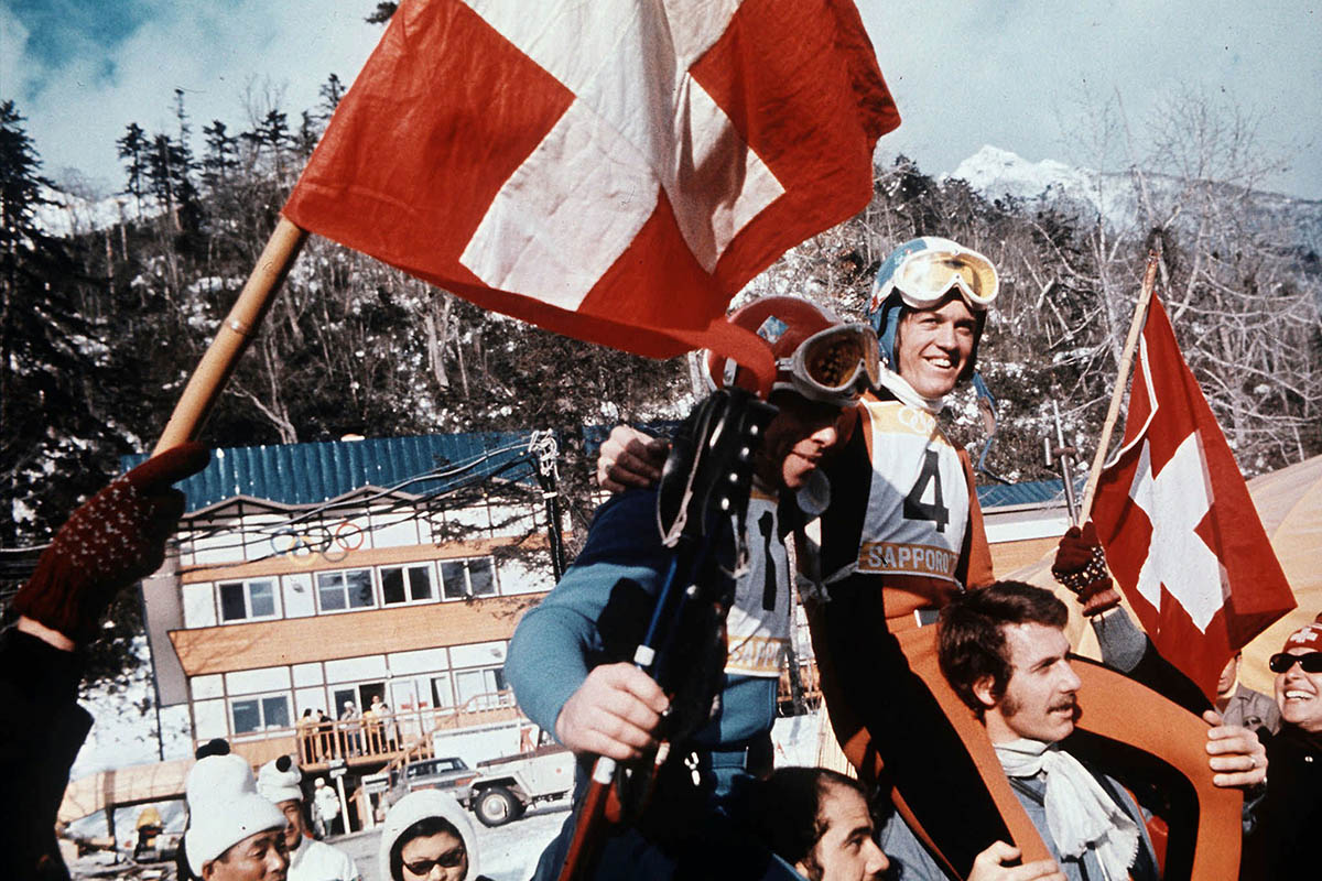 553371 - Keystone-SDA/Str - An den Olympischen Winterspielen 1972 feierte die Schweizer Delegation die «goldenen Tage von Sapporo». Hinter der Sowjetunion und der DDR belegte die Schweiz in der Nationenwertung Platz 3 – auch dank Bernhard Russi und Roland Collombin, die in der Abfahrt Gold und Silber gewannen.
